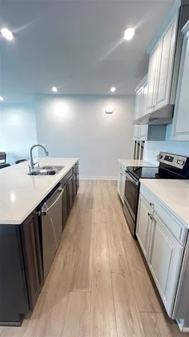a kitchen with granite countertop a sink stove and cabinets