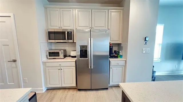 a kitchen with white cabinets and stainless steel appliances