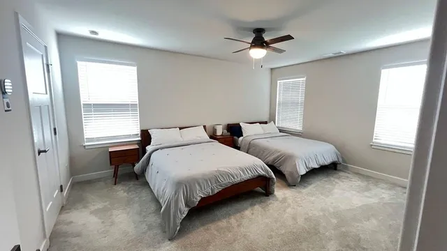 a spacious bedroom with two beds and a window