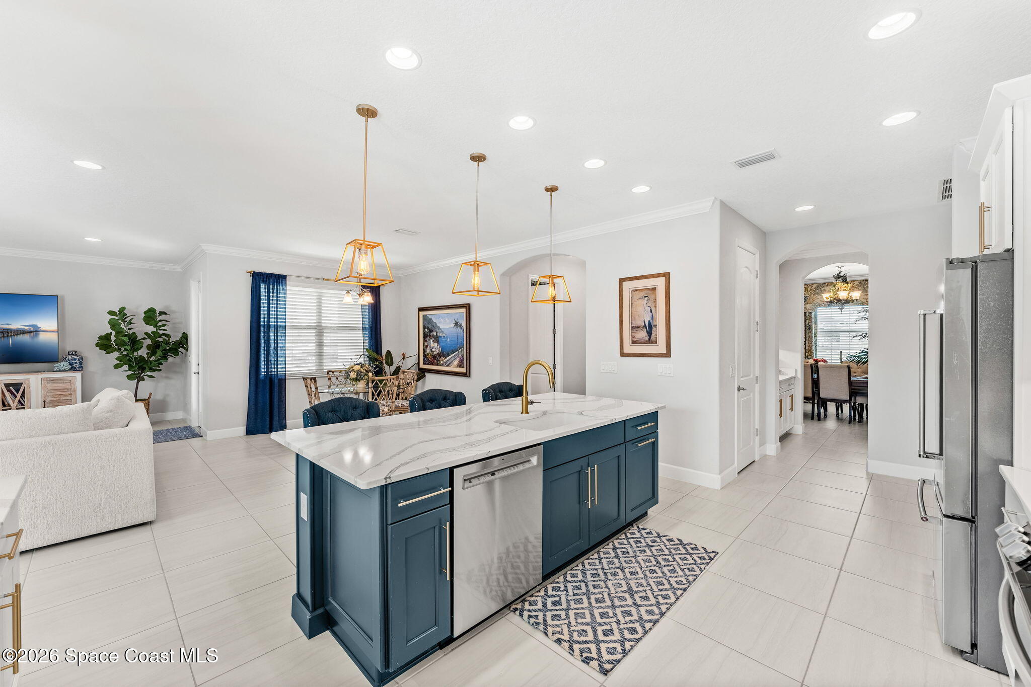 3135 Addison Drive Melbourne, FL 32940 - Photo 9 of 51 a large living room with stainless steel appliances kitchen island granite countertop a large kitchen island a stove a sink a dining table and chairs with wooden floor