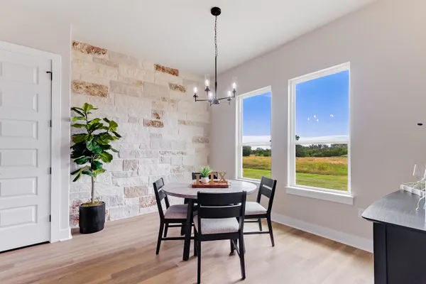 a dining room with furniture potted plants and wooden floor