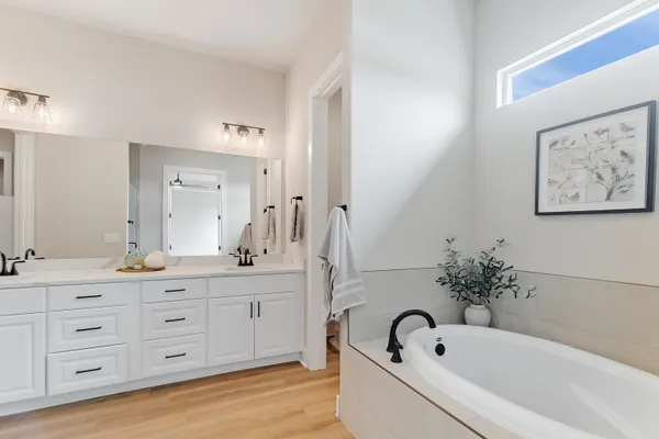 a bathroom with a tub a sink and mirrors
