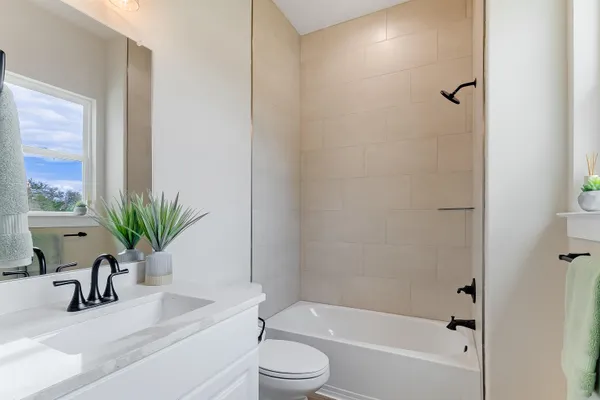 a bathroom with a sink a toilet a tub and shower