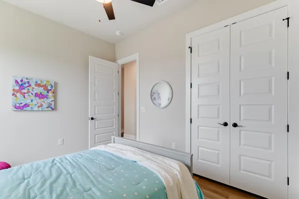 a bedroom with bed and wooden floor