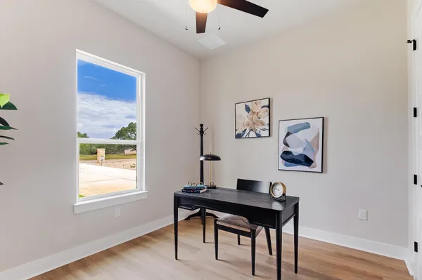 a view of a workspace with furniture and a window