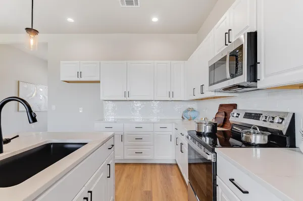 a kitchen with stainless steel appliances a stove a sink a stove and cabinets