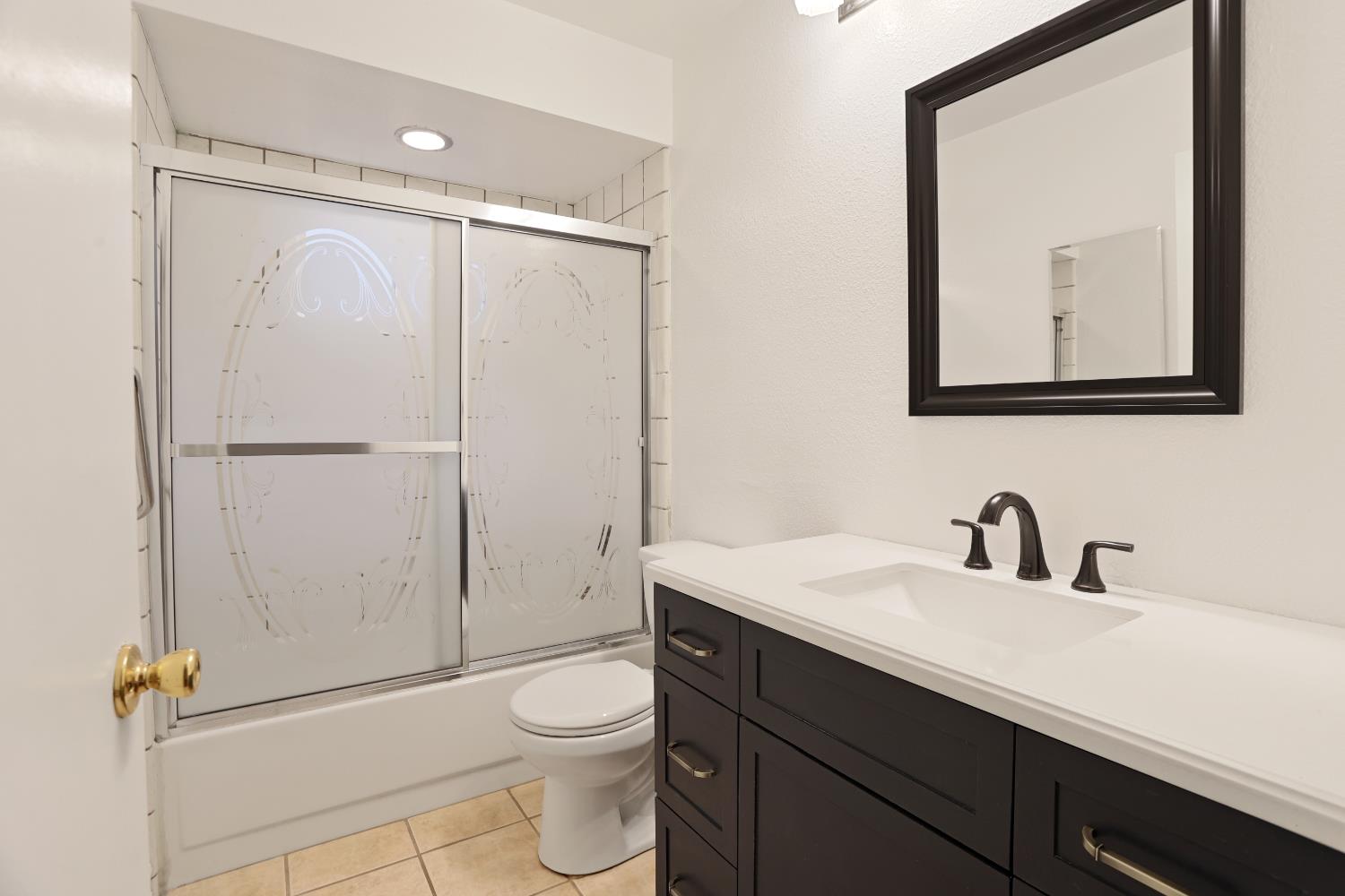 1417 Fransen Lane Modesto, CA 95355 - Photo 11 of 30 a bathroom with a toilet a sink a mirror a vanity and shower
