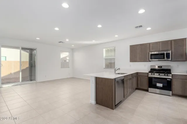 a kitchen with stainless steel appliances granite countertop a stove a sink and a refrigerator