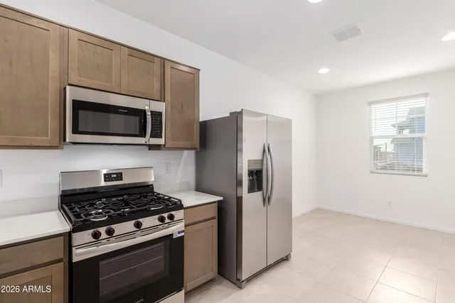 a kitchen with stainless steel appliances a stove a microwave and white cabinets