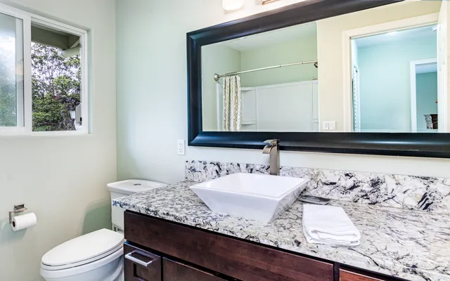 a bathroom with a granite countertop sink and a mirror