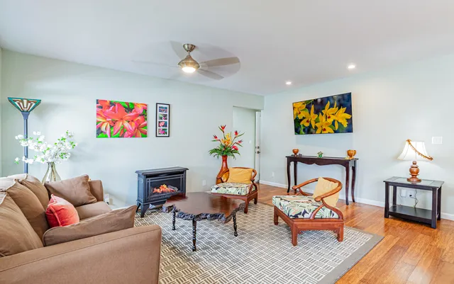a living room with furniture kitchen view and a potted plant