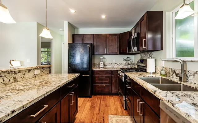 a kitchen with a sink stove top oven and refrigerator
