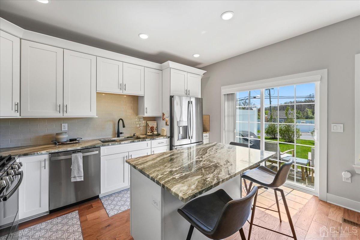 1404 Tavern Road Monroe Township, NJ 08831 - Photo 12 of 29 a kitchen with kitchen island granite countertop a table chairs sink and cabinets