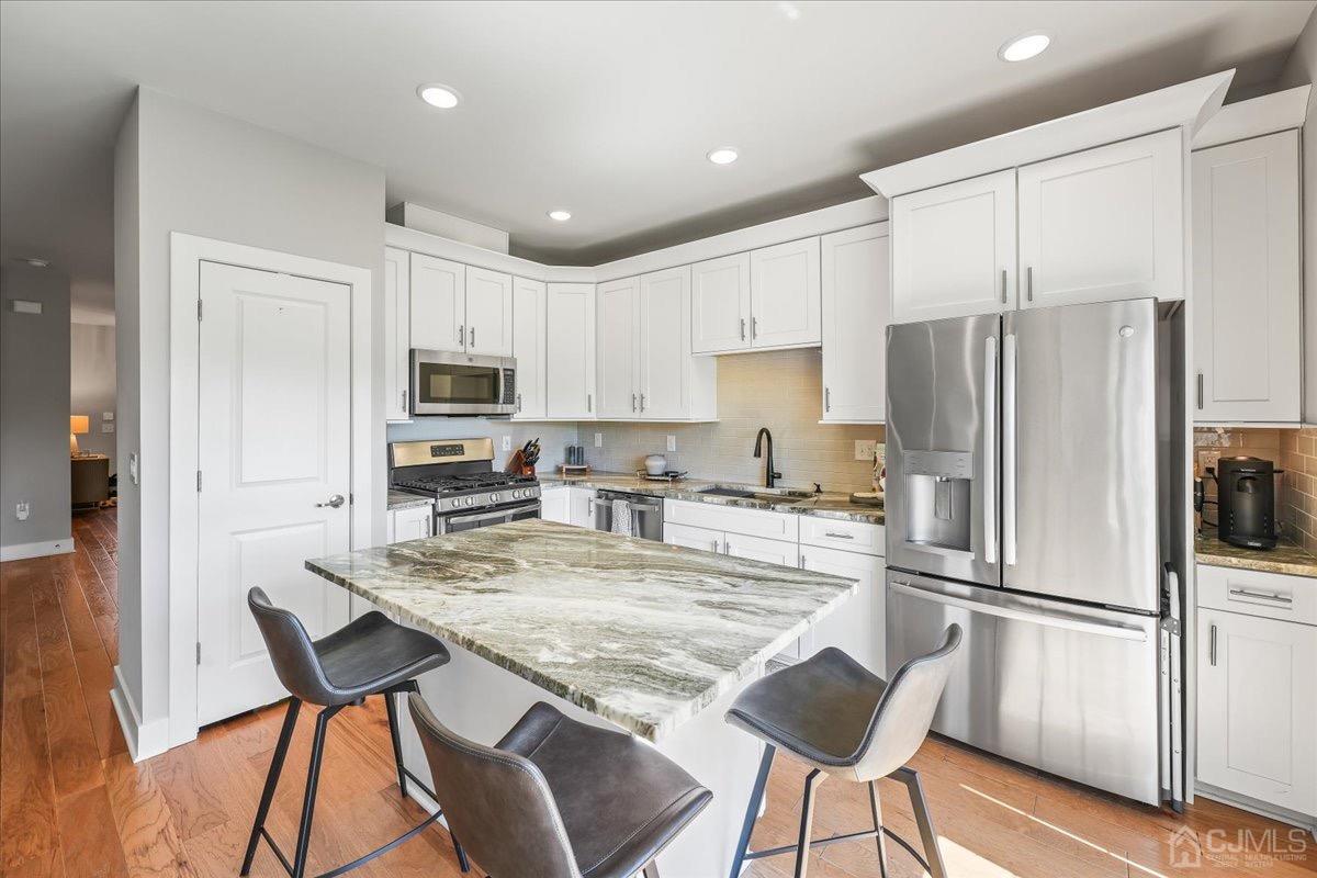 1404 Tavern Road Monroe Township, NJ 08831 - Photo 13 of 29 a kitchen with granite countertop a refrigerator stove microwave and cabinets