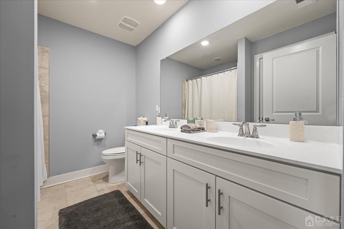 1404 Tavern Road Monroe Township, NJ 08831 - Photo 22 of 29 a bathroom with a sink a toilet and a mirror