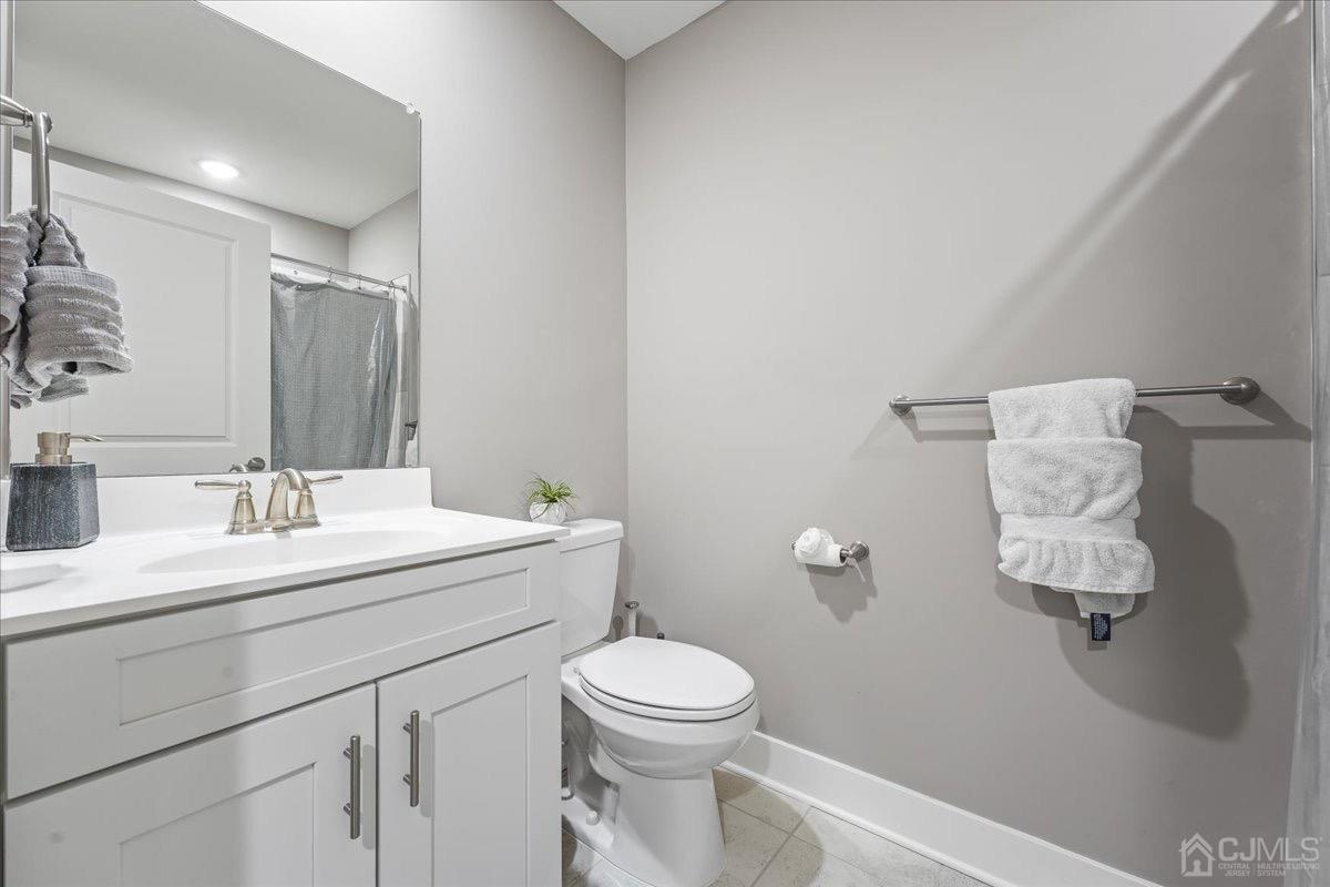 1404 Tavern Road Monroe Township, NJ 08831 - Photo 27 of 29 a bathroom with a toilet sink vanity and mirror