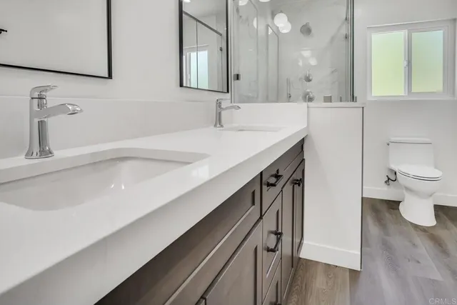 a bathroom with a sink a toilet and a mirror