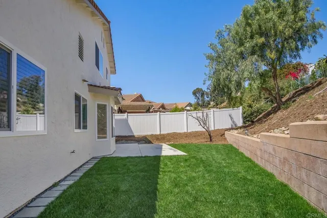 a view of a house with backyard and sitting area