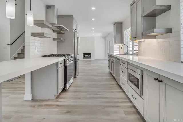 a large kitchen with stainless steel appliances kitchen island granite countertop a large counter top a sink and a stove