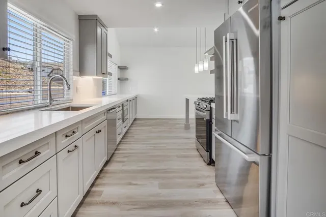 a kitchen with white cabinets and refrigerator