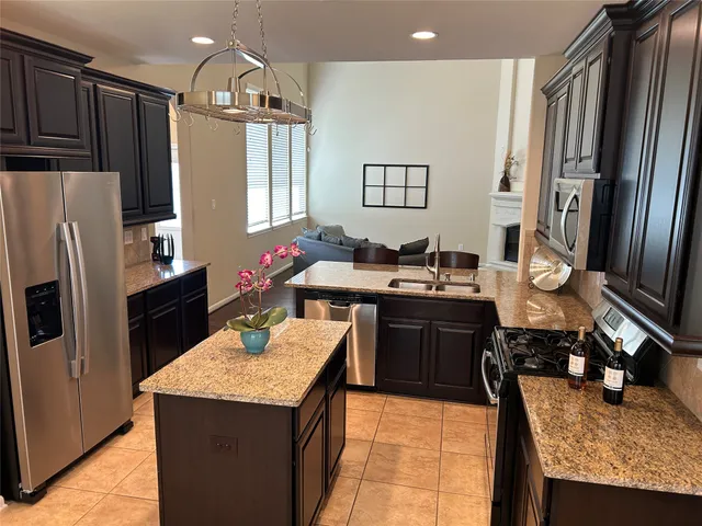 a kitchen with granite countertop a stove and a microwave