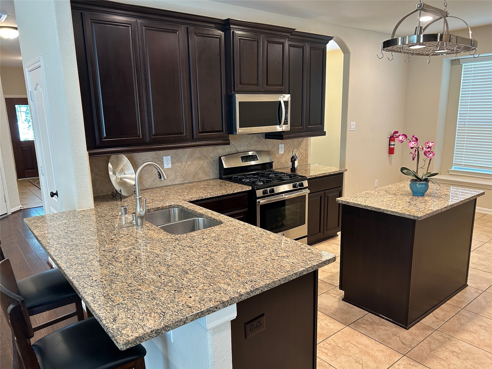 6819 Hunters Trace Lane Baytown, TX 77521 - Photo 15 of 32 a kitchen with granite countertop stainless steel appliances a sink dishwasher microwave stove and cabinets