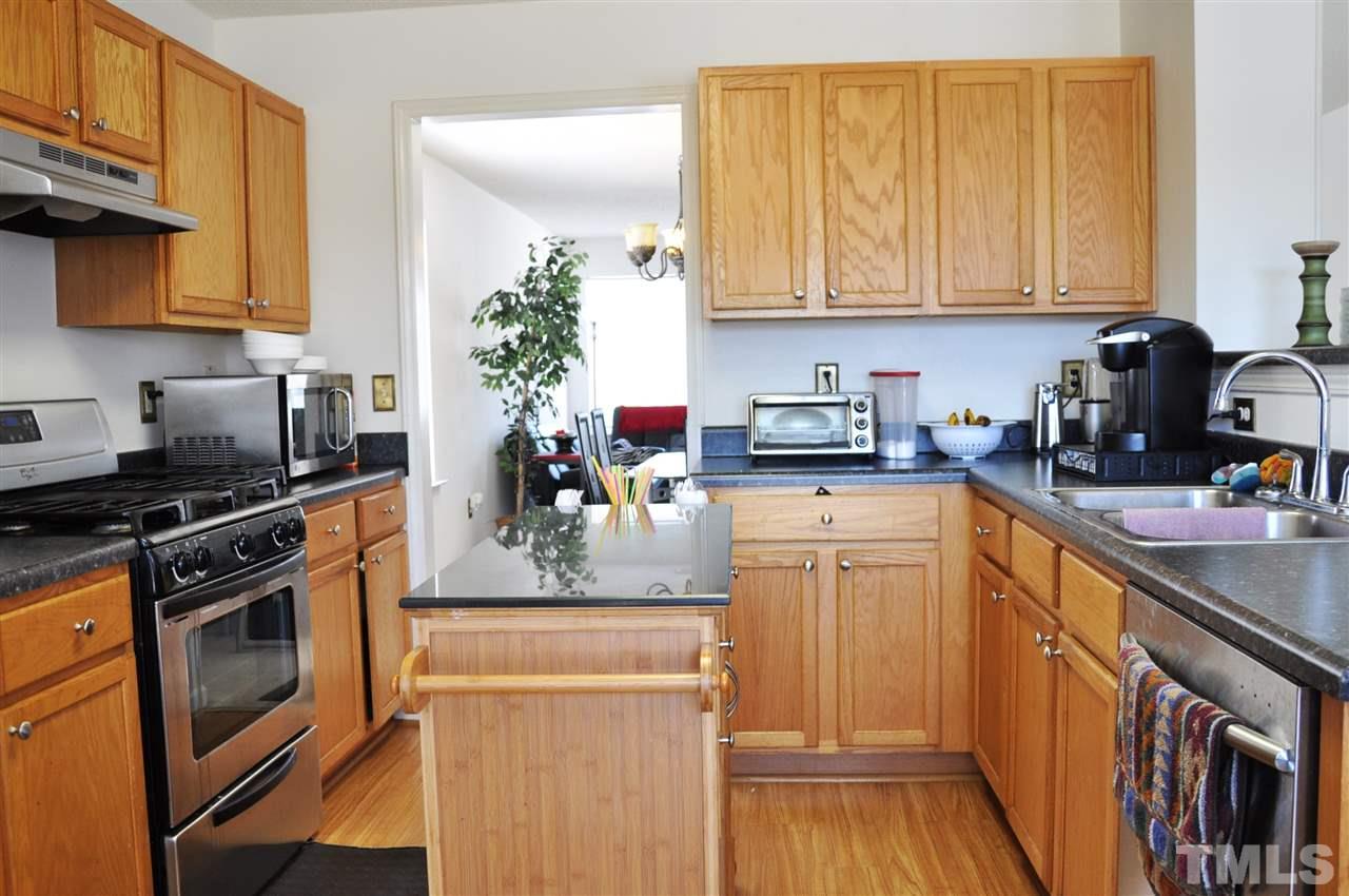 3305 Marcony Way Raleigh, NC 27610 - Photo 2 of 25 a kitchen with stainless steel appliances granite countertop a stove a sink dishwasher and cabinets with wooden floor