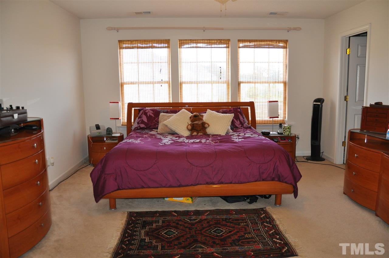 3305 Marcony Way Raleigh, NC 27610 - Photo 16 of 25 a bedroom with a bed and wooden floor