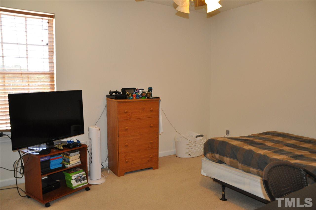 3305 Marcony Way Raleigh, NC 27610 - Photo 21 of 25 a bedroom with a bed and a flat tv screen on top of it
