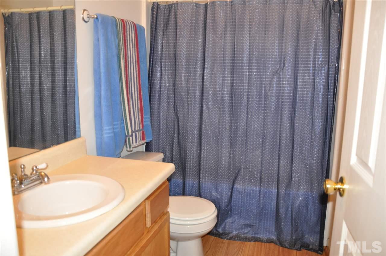 3305 Marcony Way Raleigh, NC 27610 - Photo 22 of 25 a bathroom with a sink a toilet and shower curtain