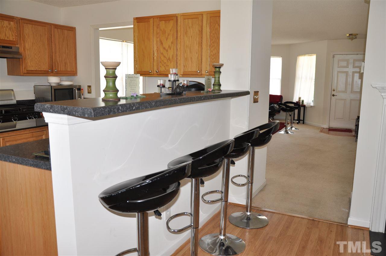 3305 Marcony Way Raleigh, NC 27610 - Photo 4 of 25 a view of a kitchen with kitchen island a counter top a stove a sink and a window