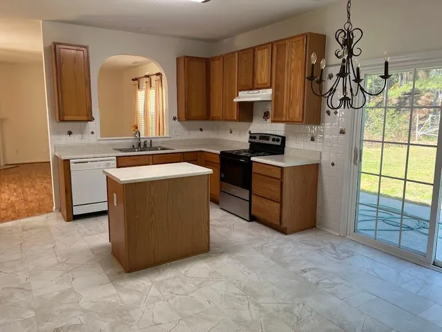 a kitchen with stainless steel appliances granite countertop a stove a sink and a microwave