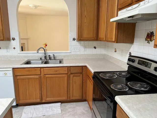 a kitchen with stainless steel appliances granite countertop a sink stove and cabinets