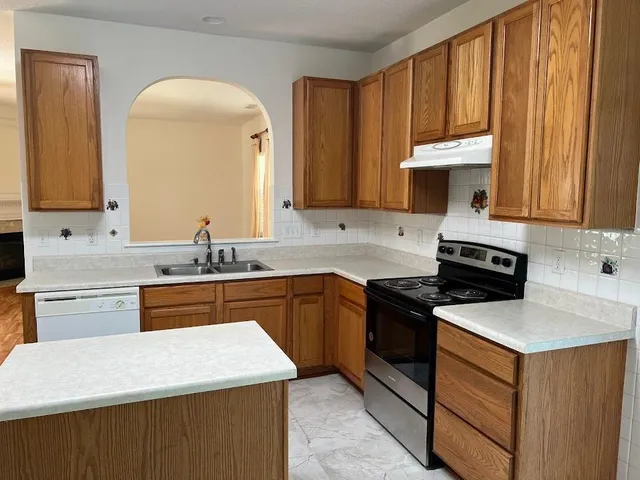 a kitchen with granite countertop cabinets stainless steel appliances and a sink