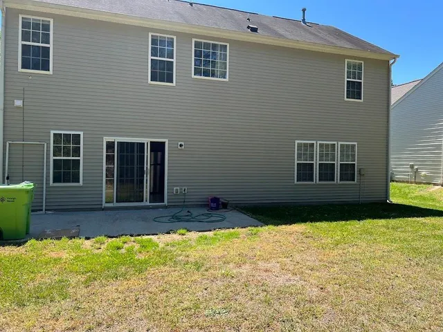 a view of a house with backyard and sitting area