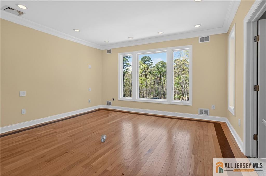381 Monmouth Road Freehold, NJ 07728 - Photo 24 of 63 a view of an empty room with wooden floor and a window