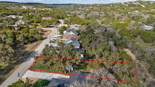 an aerial view of residential houses with outdoor space and trees