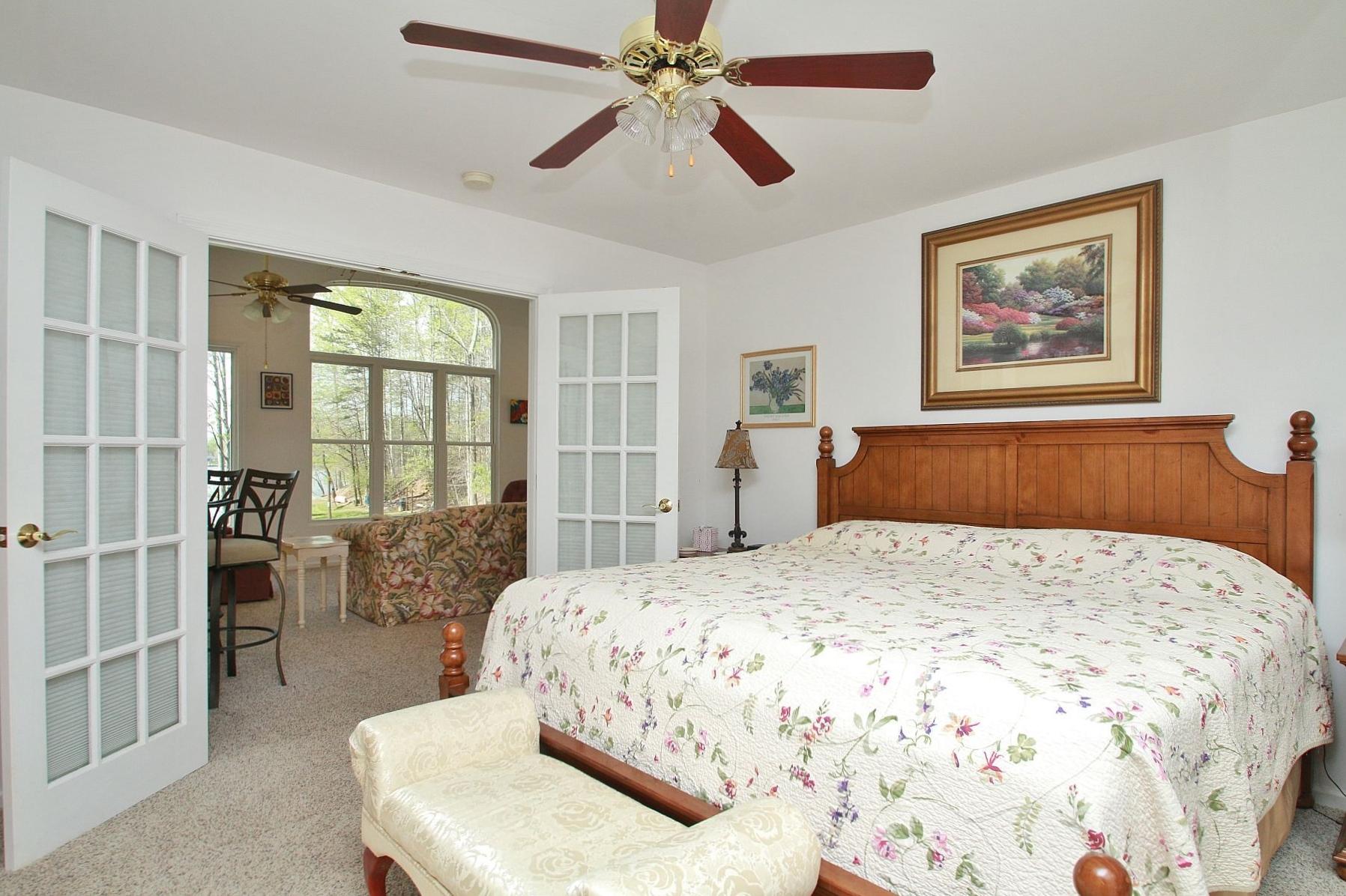 5965 Horseshoe Bend Road Goodview, VA 24095 - Photo 19 of 33 a bedroom with a large bed and a chandelier