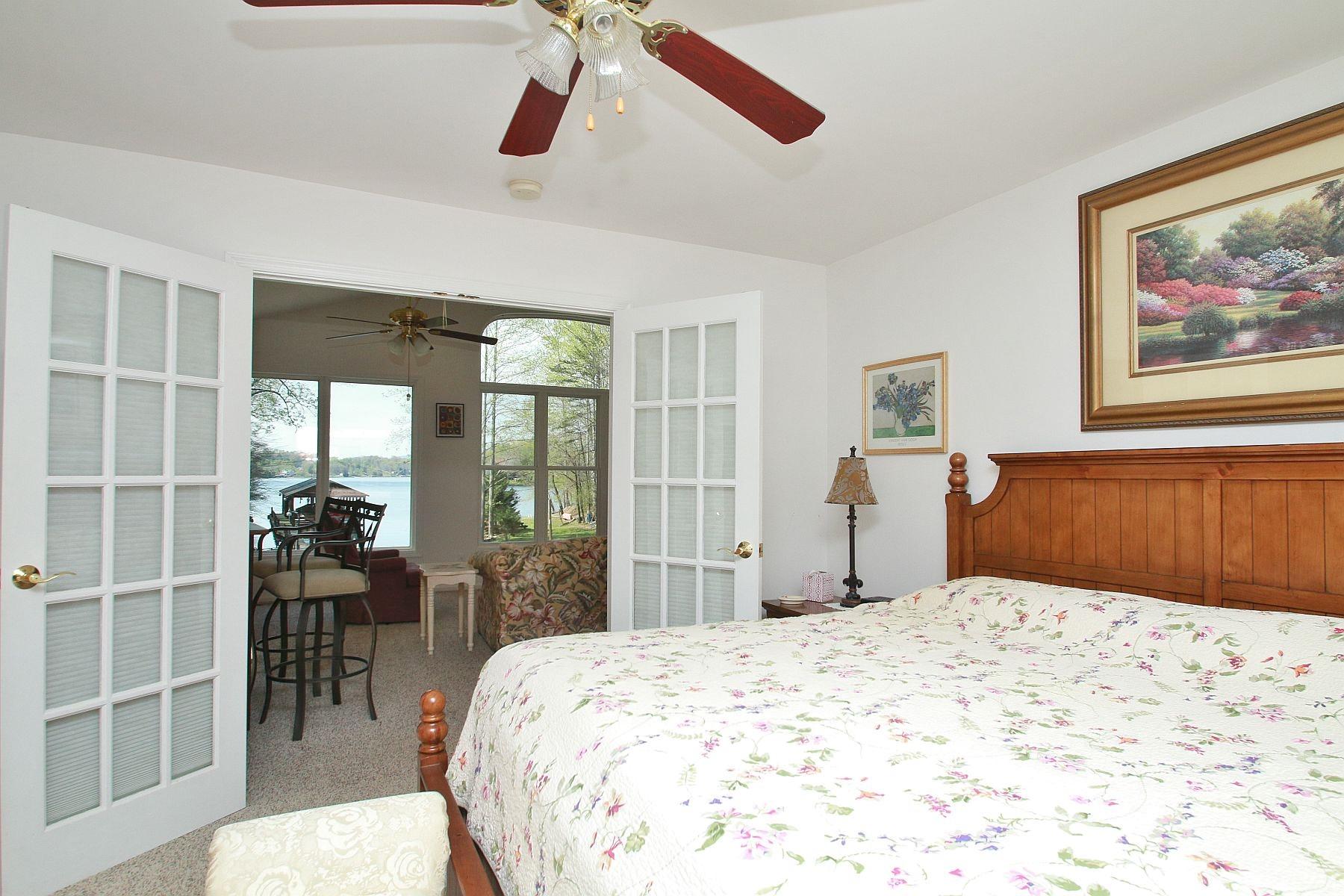 5965 Horseshoe Bend Road Goodview, VA 24095 - Photo 20 of 33 a bedroom with a large bed and a chandelier