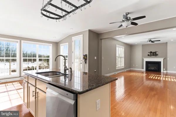 a kitchen with granite countertop a stove a sink and a refrigerator