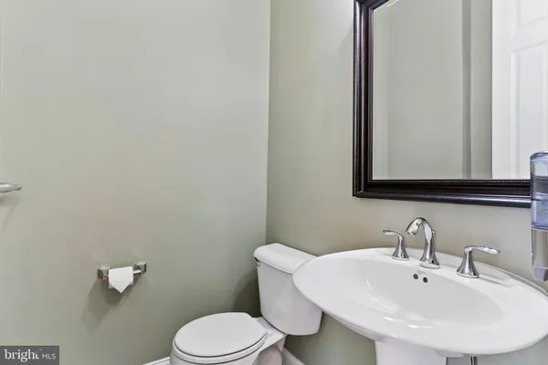 a bathroom with a toilet a sink and mirror