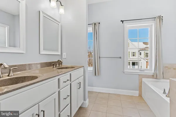 a bathroom with a granite countertop sink mirror and bathtub