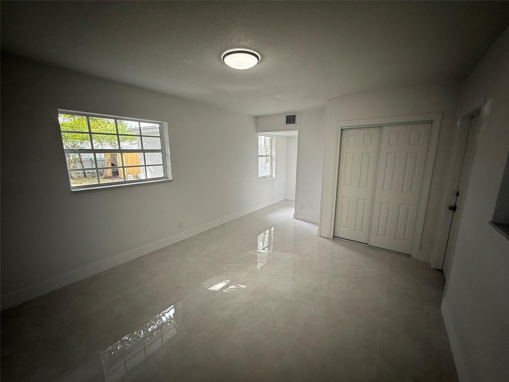 1724 Northeast 50th Court Pompano Beach, FL 33064 - Photo 11 of 13 an empty room with windows and closet