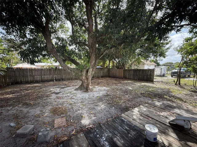 a large tree in front of a white house