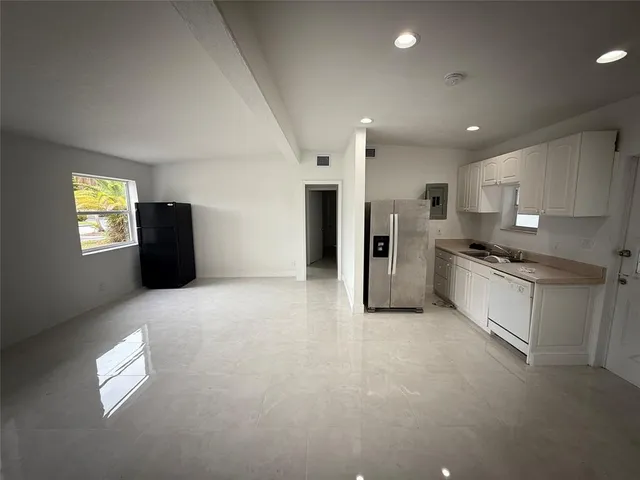 a view of a kitchen with refrigerator and windows