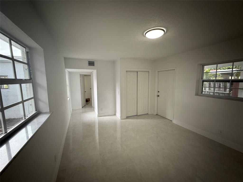 1724 Northeast 50th Court Pompano Beach, FL 33064 - Photo 6 of 13 wooden floor in an empty room with a window