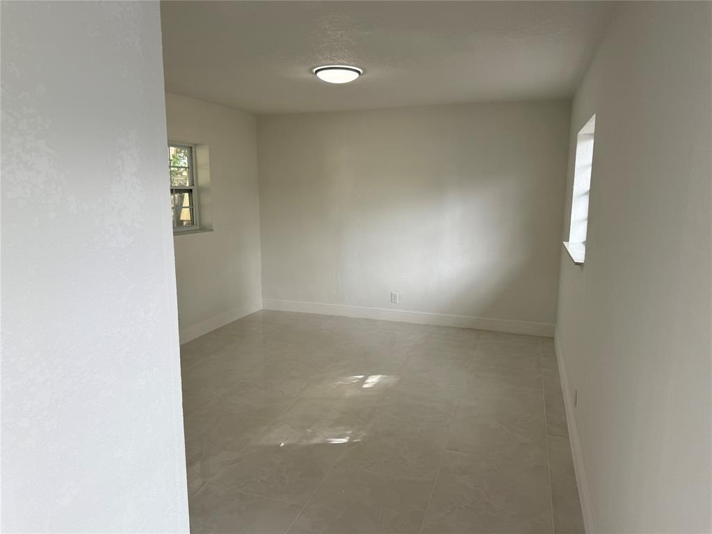 1724 Northeast 50th Court Pompano Beach, FL 33064 - Photo 9 of 13 an empty room with windows and entrance