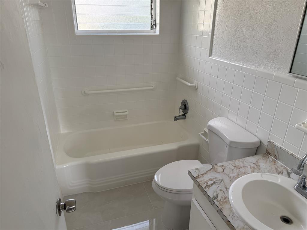 1724 Northeast 50th Court Pompano Beach, FL 33064 - Photo 10 of 13 a white toilet sitting next to a bath tub