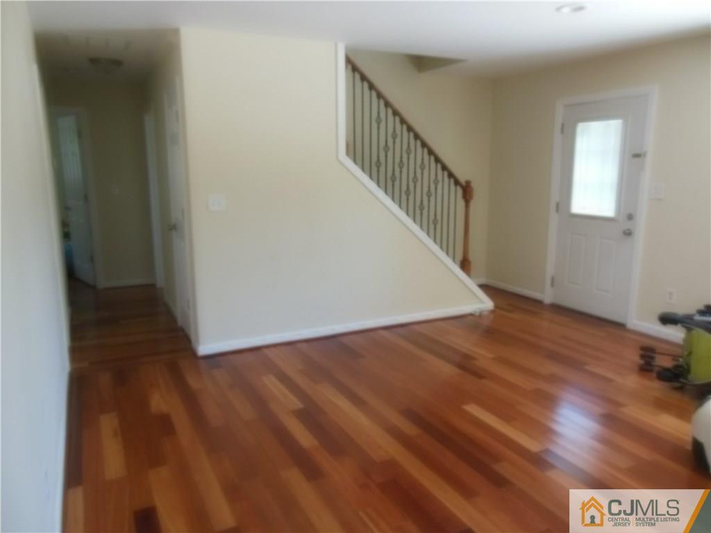 133 Idlewild Road Edison, NJ 08817 - Photo 4 of 11 a view of a hallway with wooden floor and stairs