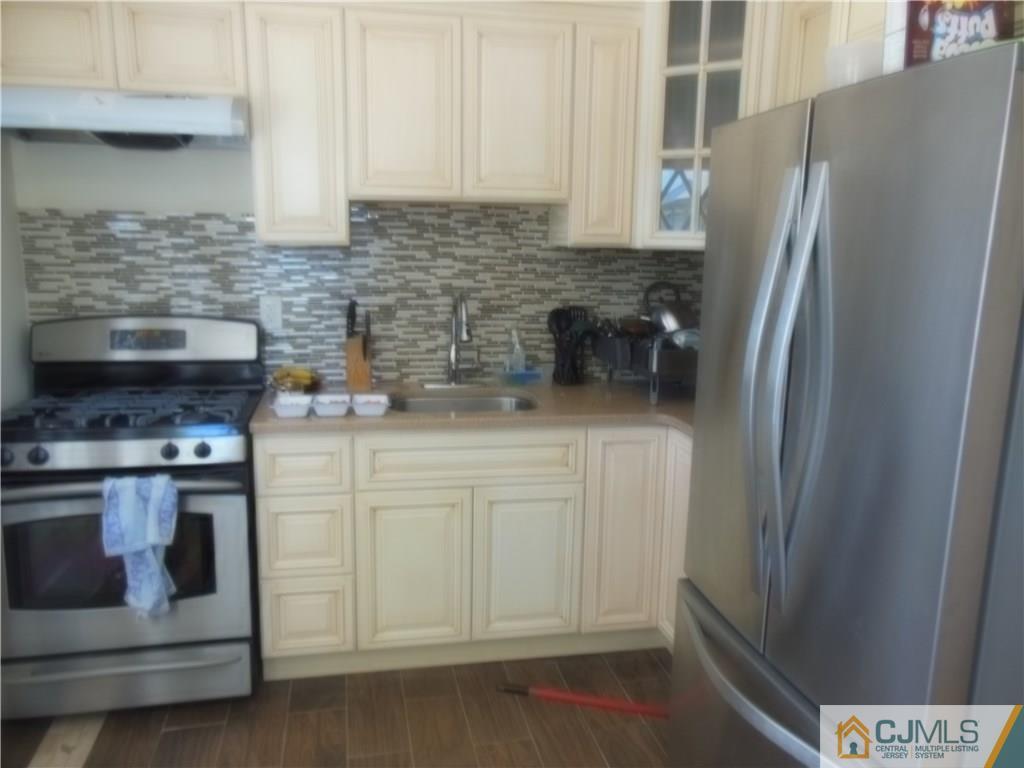 133 Idlewild Road Edison, NJ 08817 - Photo 5 of 11 a kitchen with stainless steel appliances white cabinets and a refrigerator